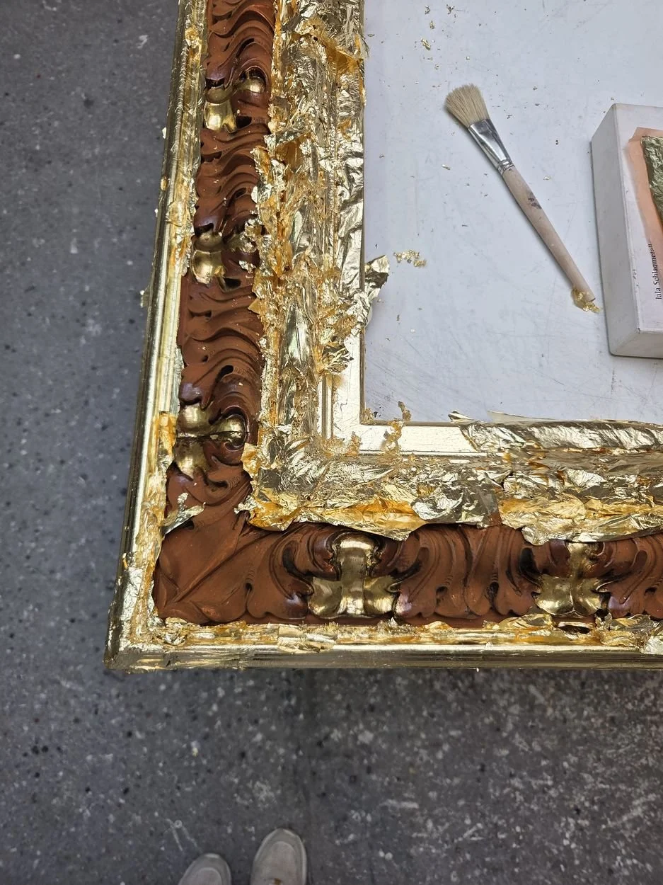 Frisch angeschossenes Blattgold auf einer Rahmenecke, noch unverputzt