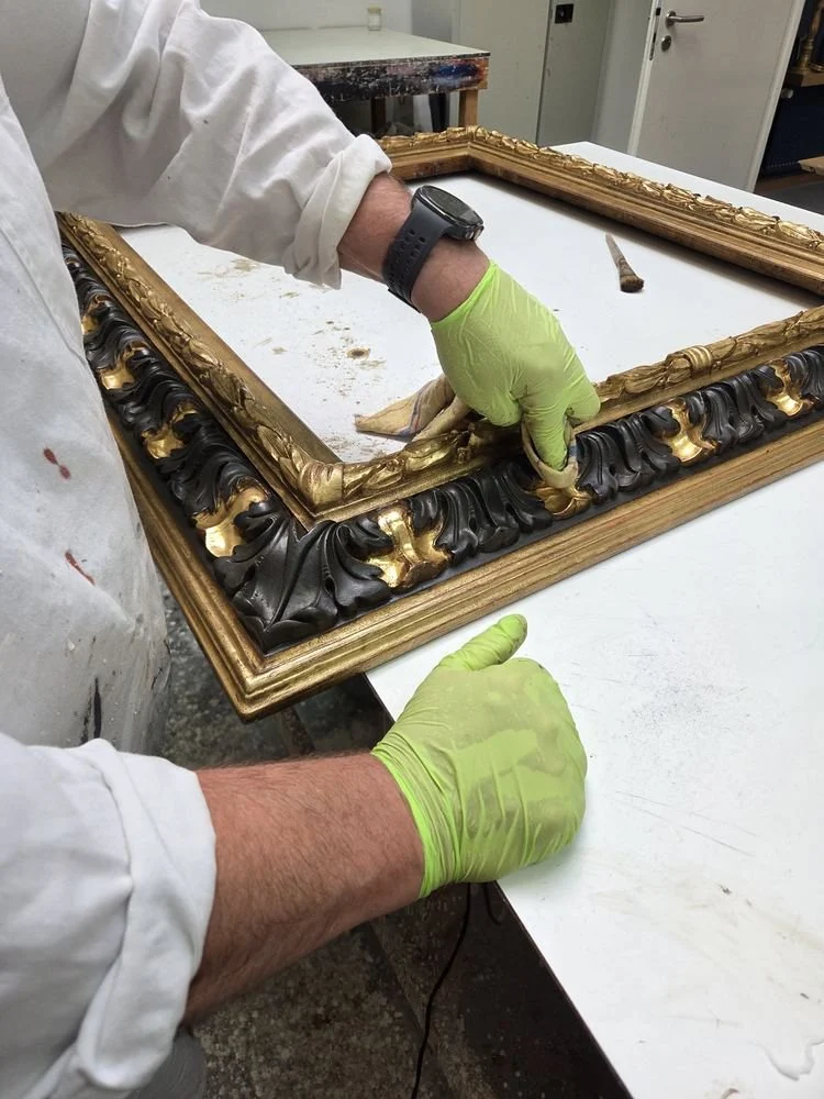 Vergolder bei der Arbeit am dunkel gefassten Ornamentband