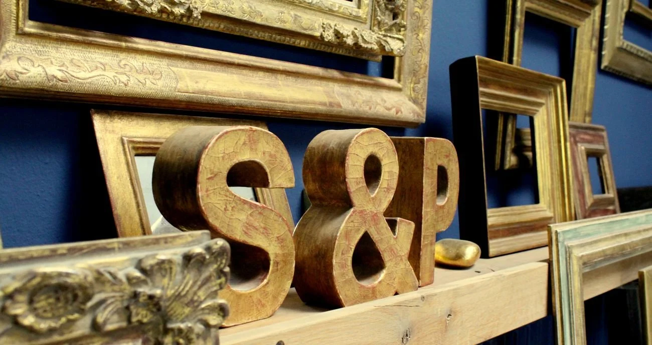 Holzbuchstaben S&P im Rahmenregal des Ateliers